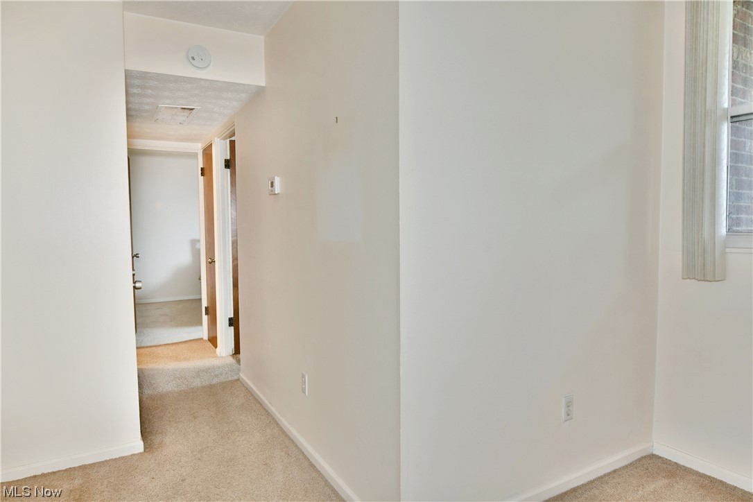 2980 North River Road Northeast, Unit E3 Warren, OH 44483 - Photo 22 of 27 Corridor featuring light colored carpet and a textured ceiling