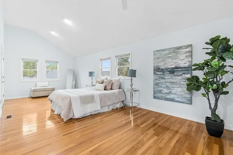 a spacious bedroom with a bed lamp closet and window