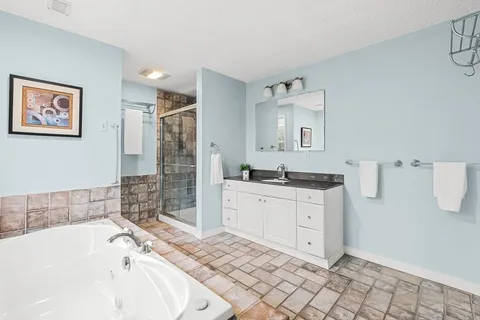 a bathroom with a bathtub sink and mirror