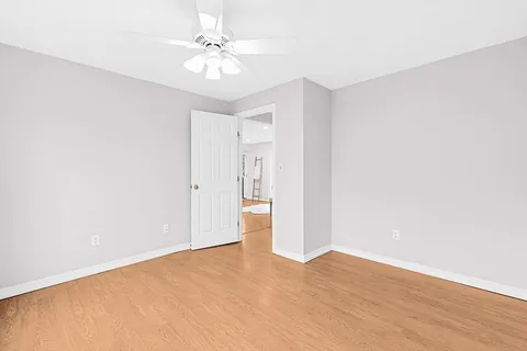 a view of an empty room with wooden floor