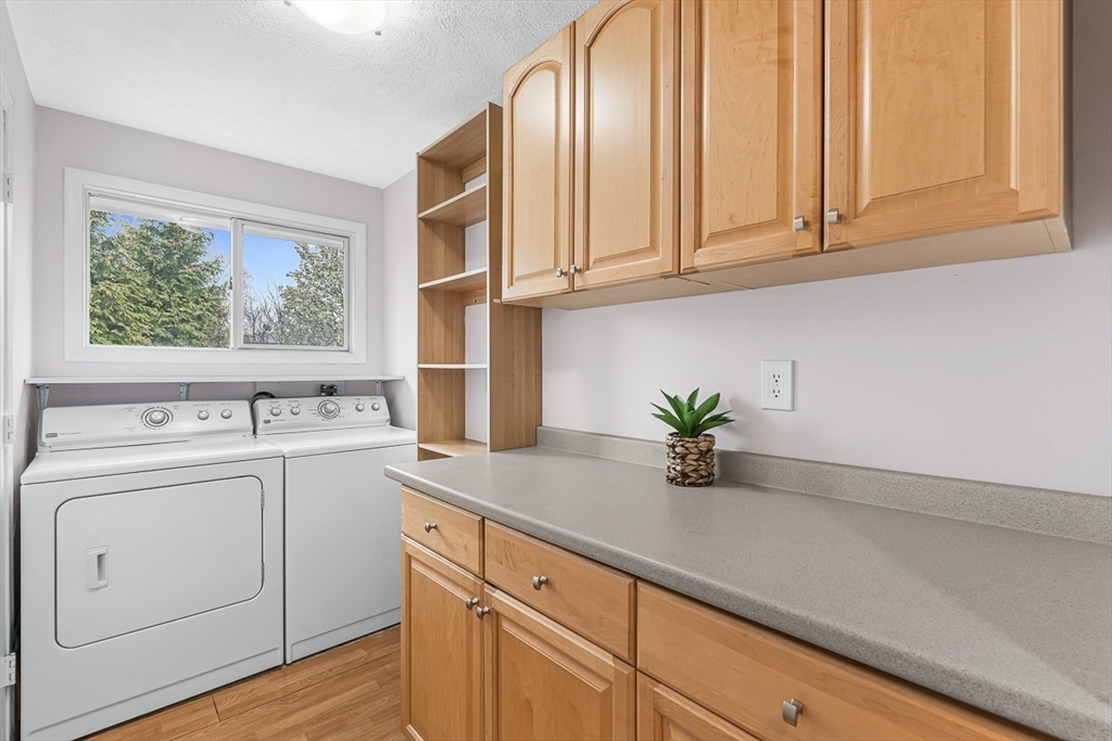 3 Theresa Road Stoneham, MA 02180 - Photo 31 of 42 a view of cabinets with wooden floor washer and dryer