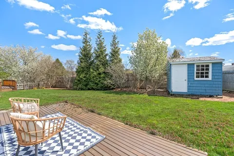 a view of a house with backyard and sitting area
