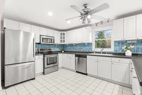 a kitchen with white cabinets and white stainless steel appliances