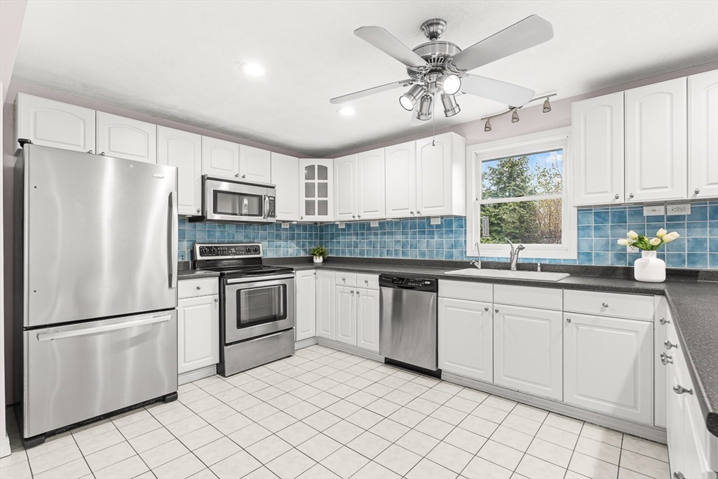 3 Theresa Road Stoneham, MA 02180 - Photo 6 of 42 a kitchen with white cabinets and white stainless steel appliances