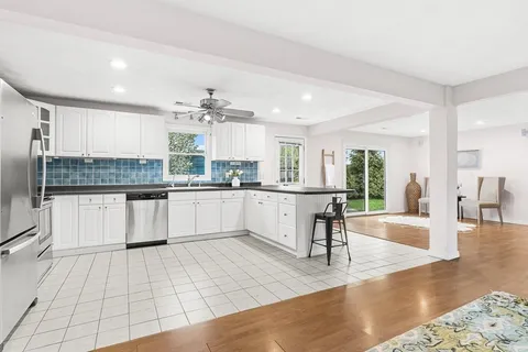 a large white kitchen with a large window