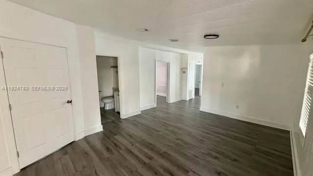an empty room with wooden floor and closet