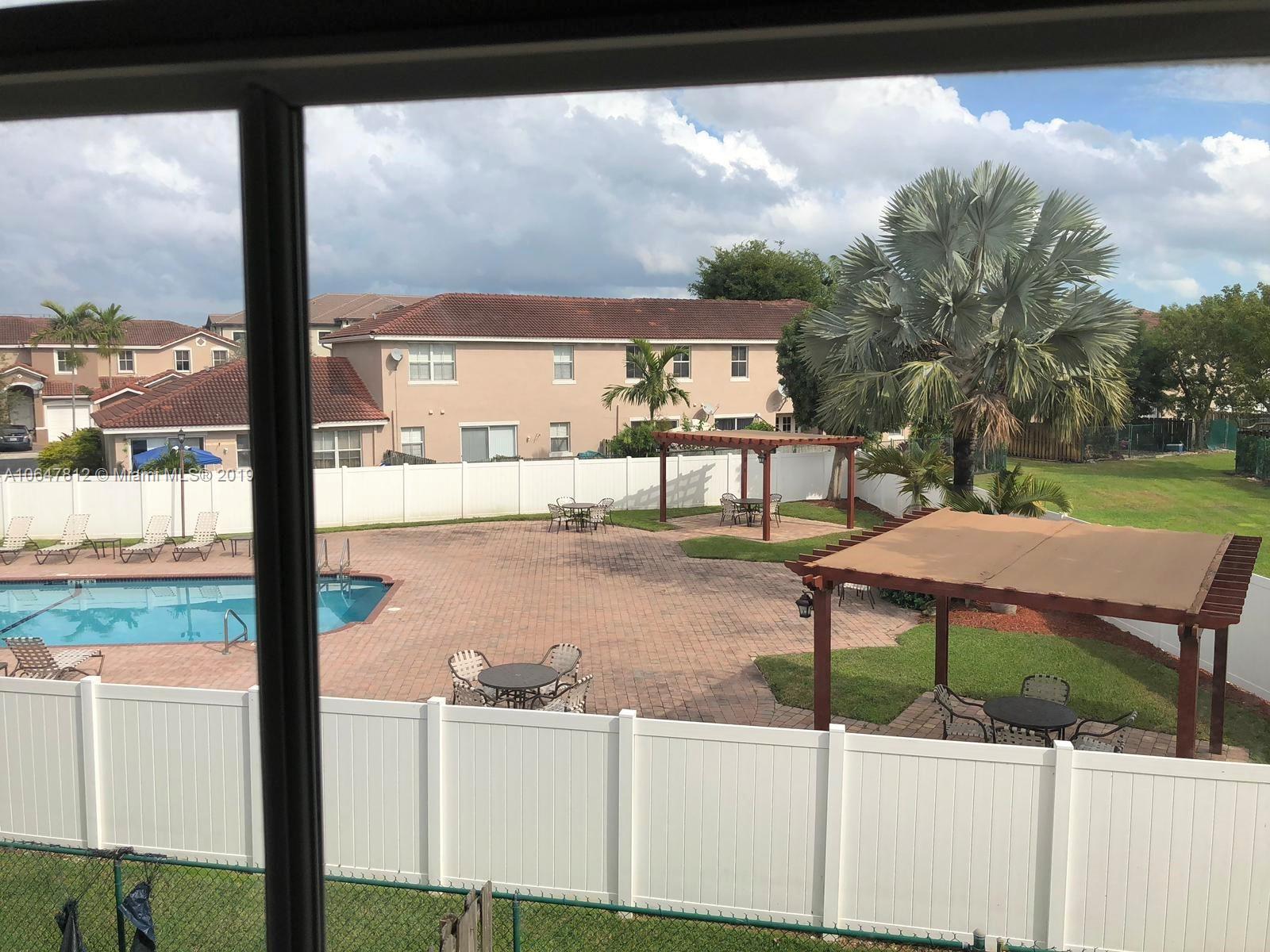 27293 Southwest 138th Path Homestead, FL 33032 - Photo 17 of 19 a table and chairs sitting in front of a yard
