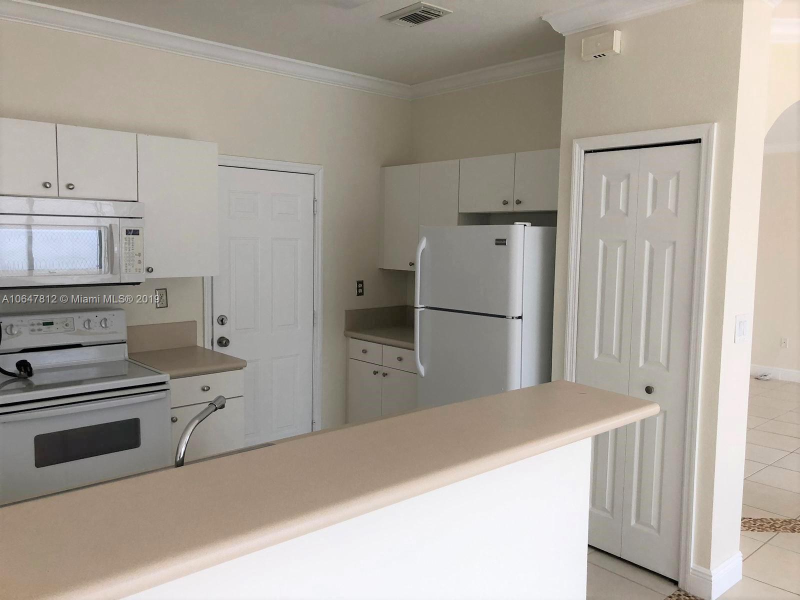27293 Southwest 138th Path Homestead, FL 33032 - Photo 6 of 19 a kitchen with a refrigerator and white cabinets