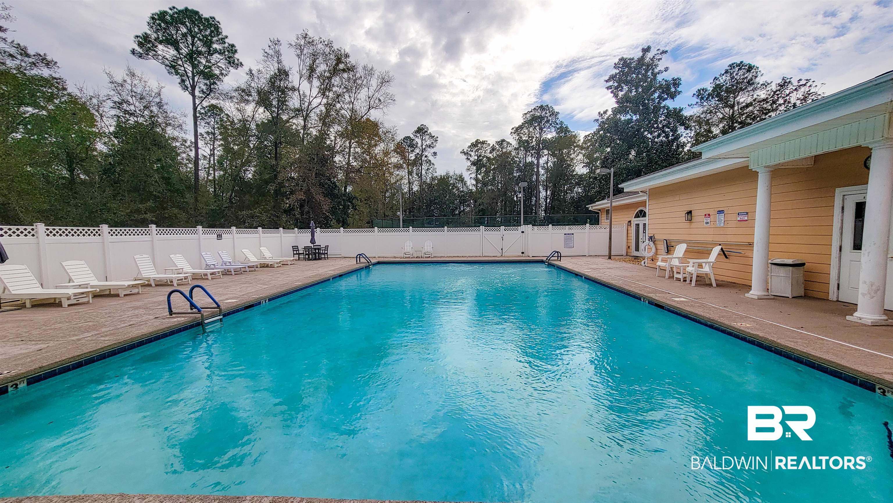 214 Hemingway Loop Foley, AL 36535 - Photo 40 of 67 Community pool featuring a patio area, a fenced backyard, and view of wooded area