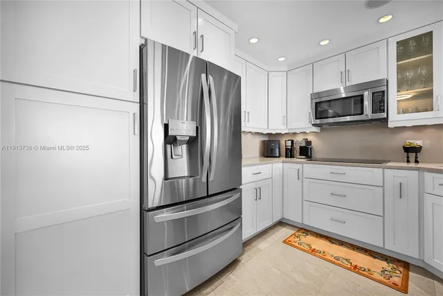 a kitchen with appliances a refrigerator and cabinets