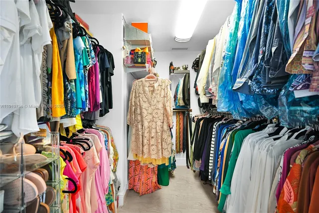 a view of walk in closet with clothes and shoes