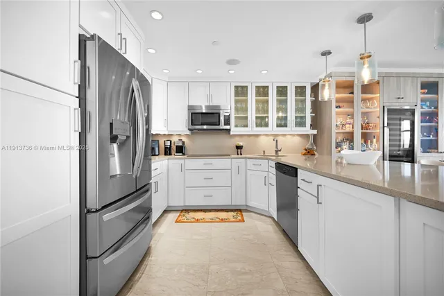 a kitchen with stainless steel appliances granite countertop a refrigerator sink and cabinets