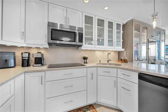 a kitchen with stainless steel appliances granite countertop white cabinets a sink and a oven