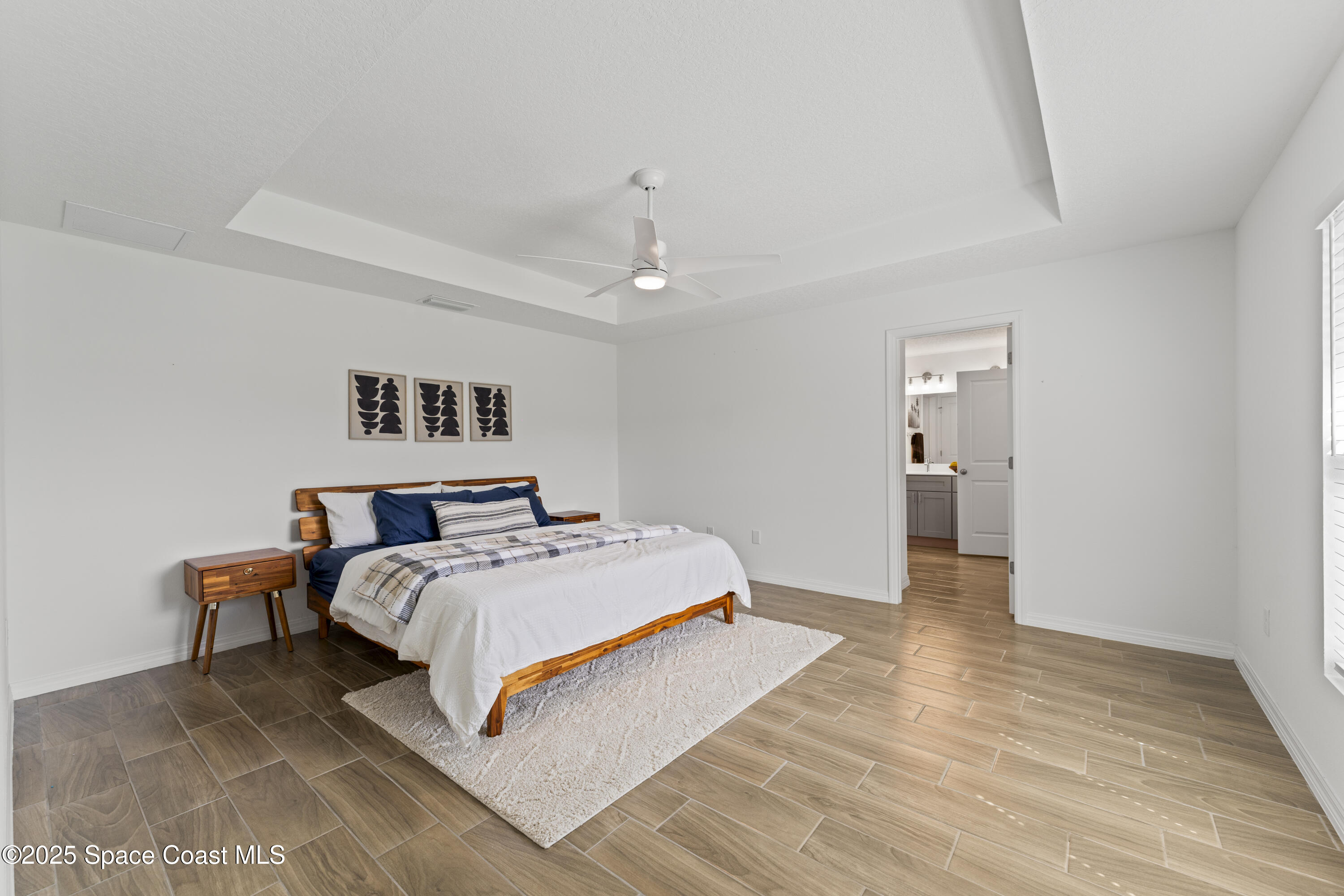 1938 Jupiter Boulevard Southwest Palm Bay, FL 32908 - Photo 11 of 21 a bedroom with a bed and a chandelier