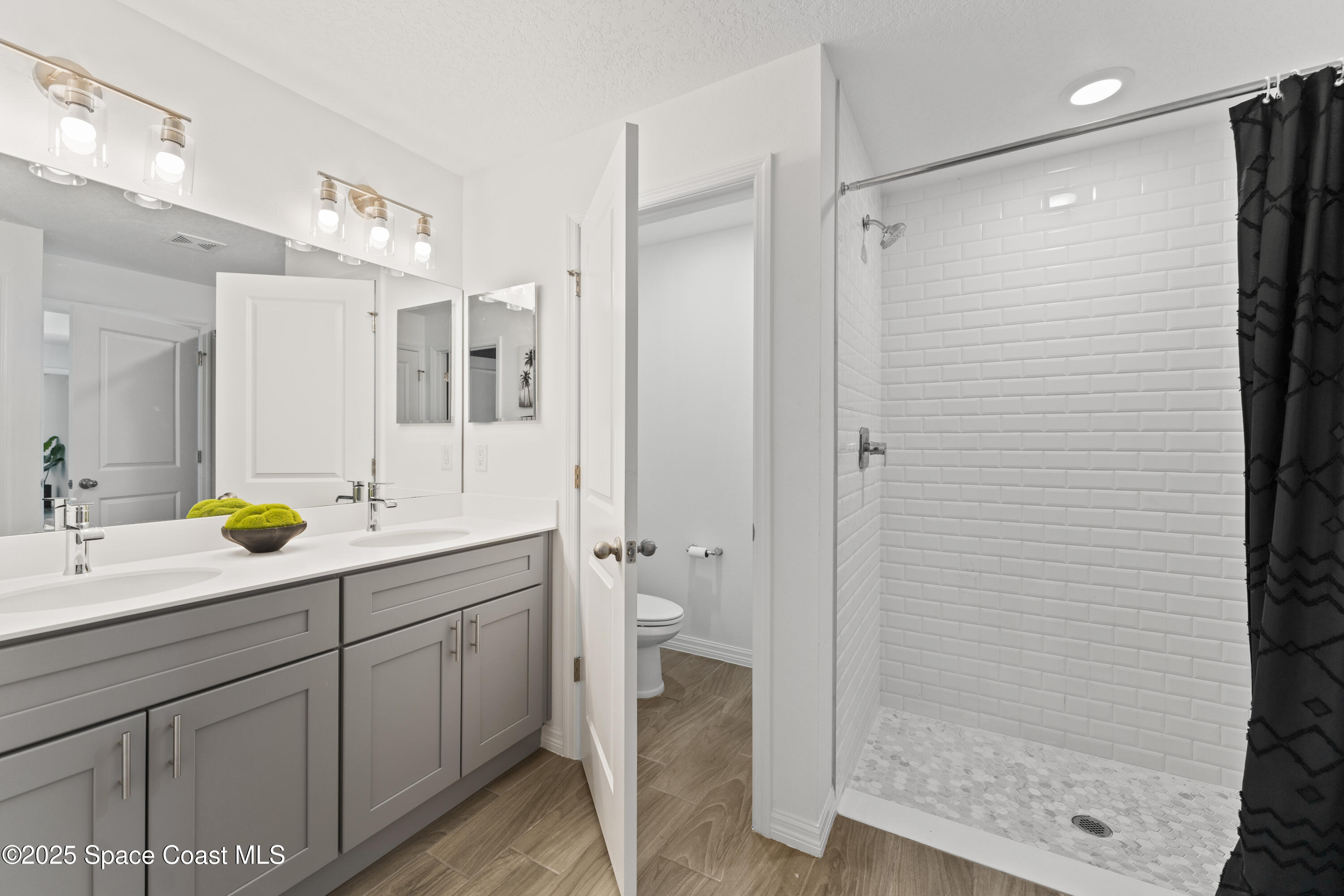 1938 Jupiter Boulevard Southwest Palm Bay, FL 32908 - Photo 13 of 21 a bathroom with a shower sink and mirror