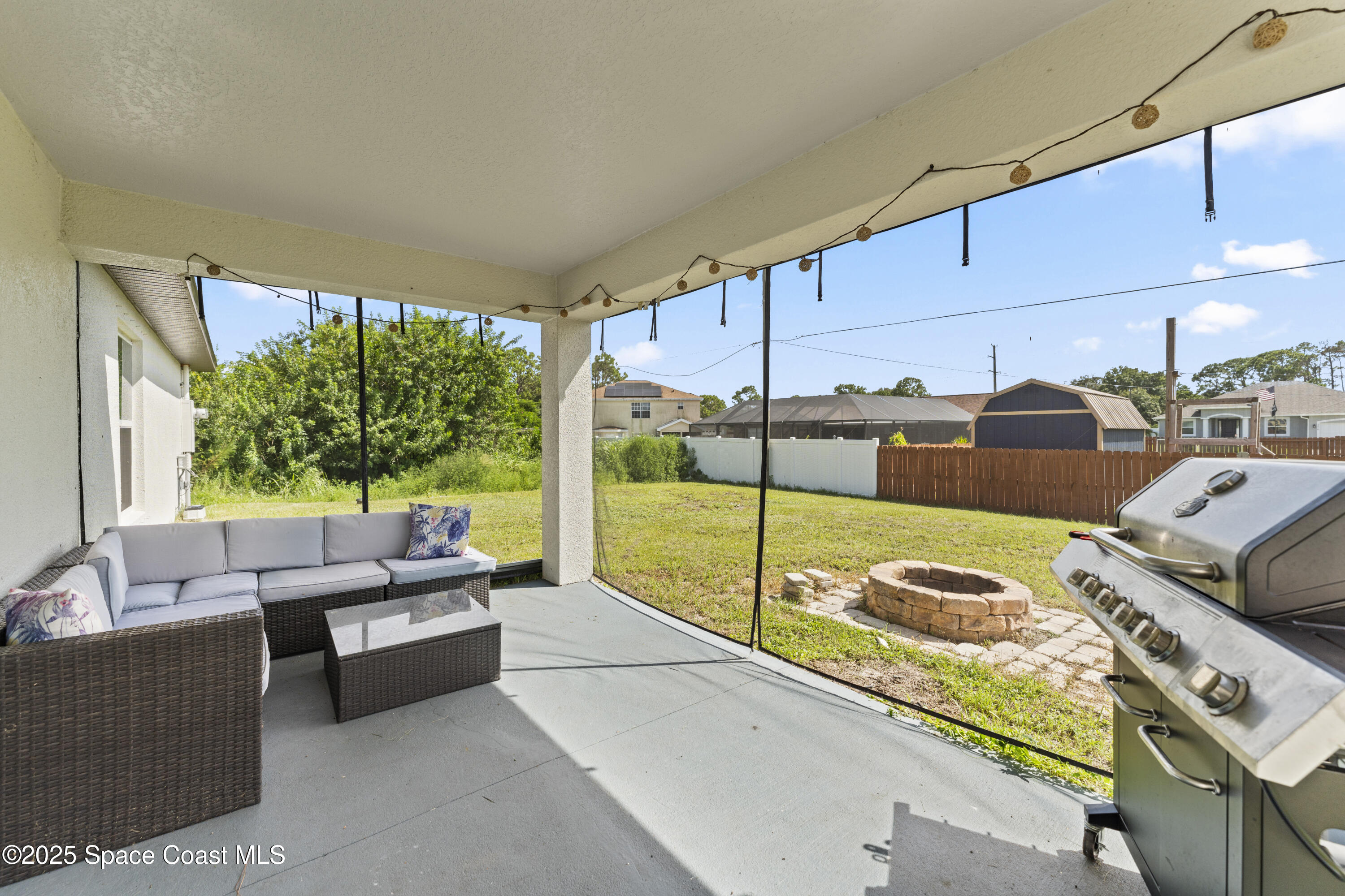 1938 Jupiter Boulevard Southwest Palm Bay, FL 32908 - Photo 20 of 21 a living room with furniture and a floor to ceiling window