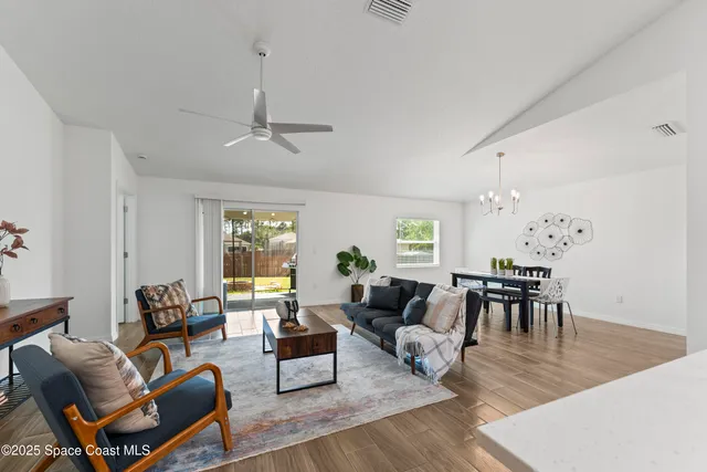 a living room with furniture dining table and a chandelier