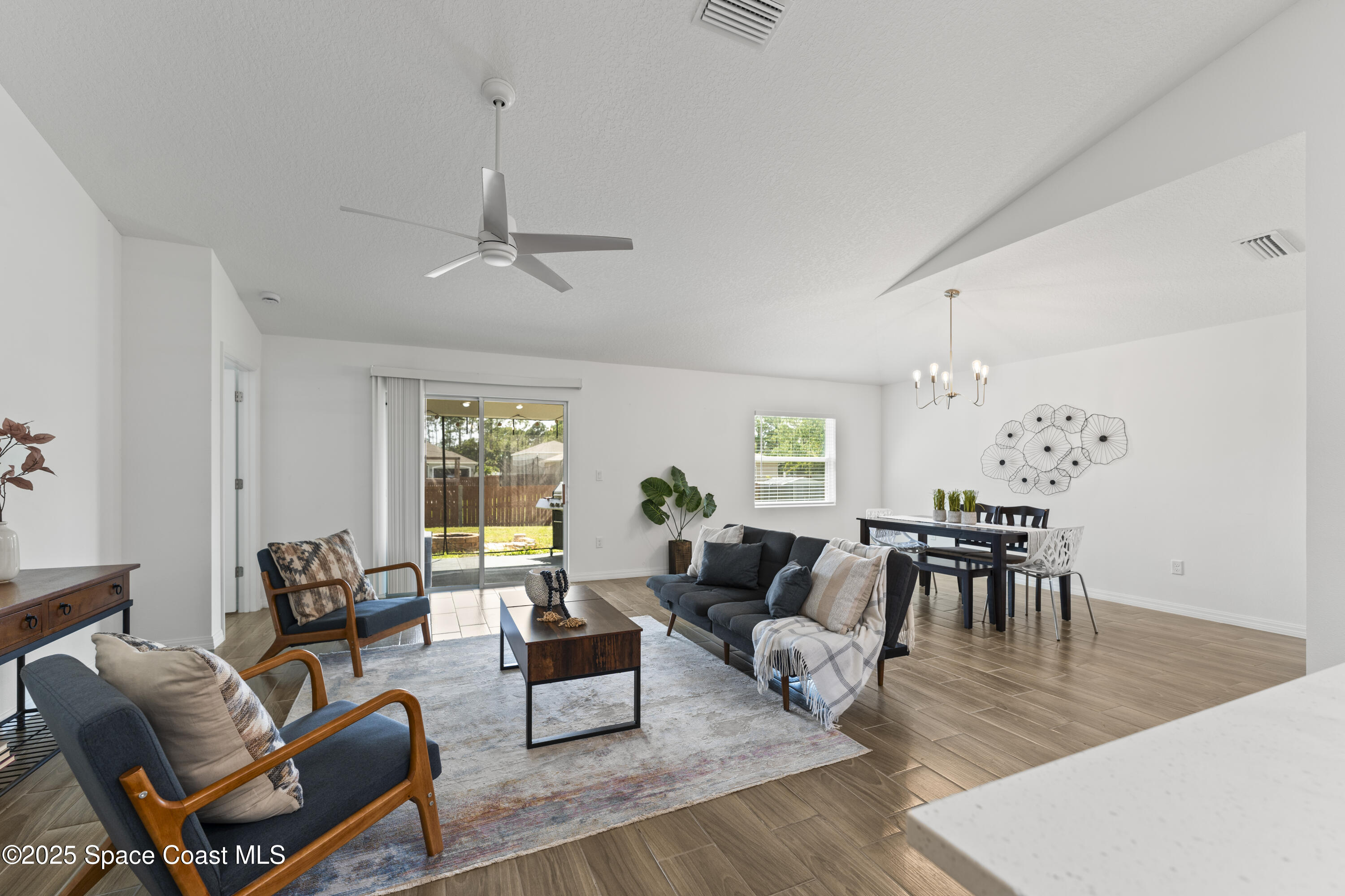 1938 Jupiter Boulevard Southwest Palm Bay, FL 32908 - Photo 7 of 21 a living room with furniture dining table and a chandelier