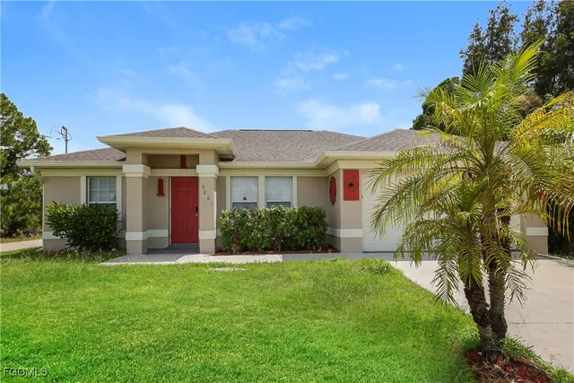 a front view of a house with a yard and potted plants