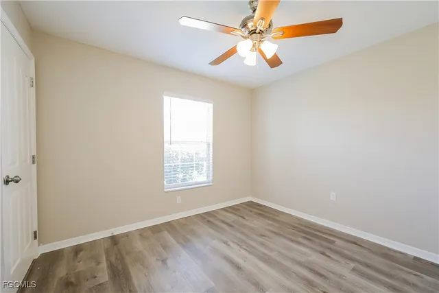 an empty room with a window and a fan