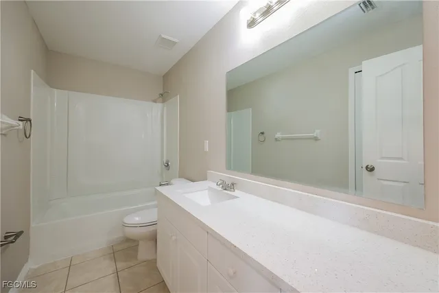 a bathroom with a granite countertop sink a toilet and shower
