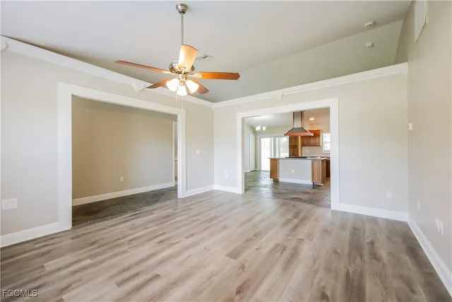 a view of an empty room with window and wooden floor