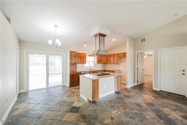 a large kitchen with granite countertop a stove a sink and a refrigerator