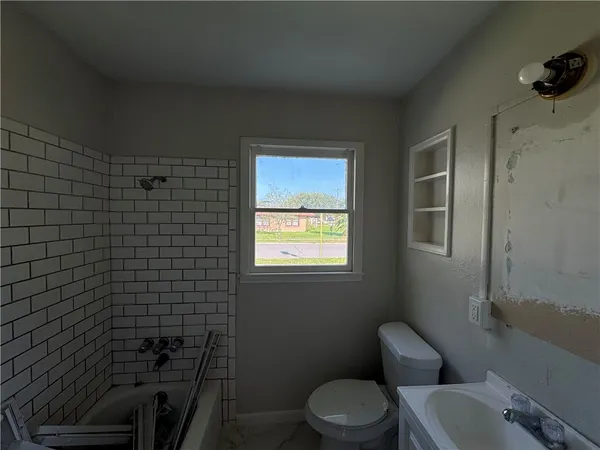 a bathroom with a toilet a sink and mirror