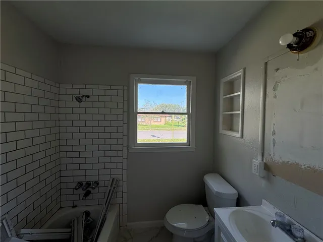 a bathroom with a toilet a sink and mirror