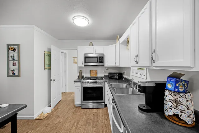 a kitchen with stainless steel appliances granite countertop a stove a sink and a microwave