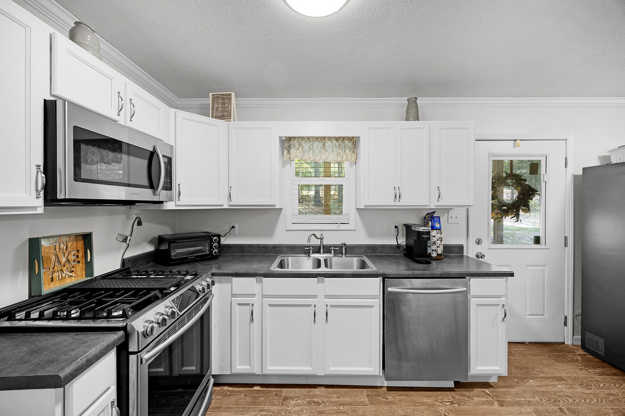 44 G & S Rock Ranch Road Camden, TN 38320 - Photo 16 of 23 a kitchen with stainless steel appliances granite countertop a stove a sink and a microwave