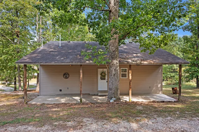 a backyard of house with a tree