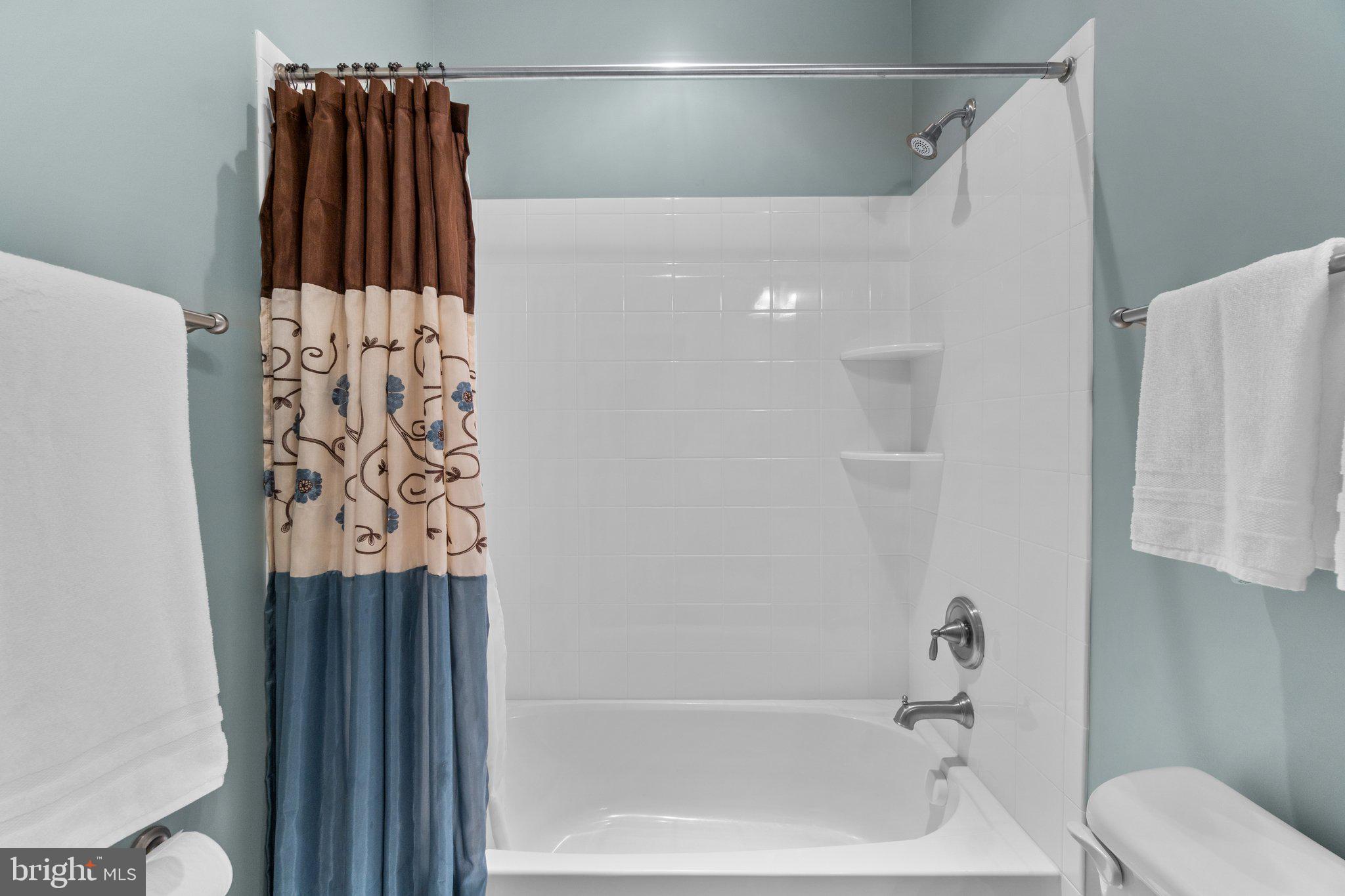 9644 Bothwell Lane Frederick, MD 21704 - Photo 32 of 68 a bathroom with a shower curtain and a bathtub