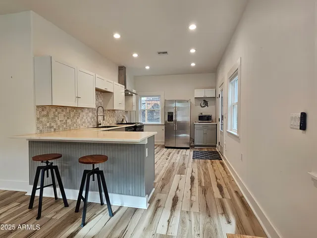 a kitchen with a table chairs refrigerator and cabinets