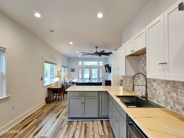 a kitchen with granite countertop a sink stove and cabinets