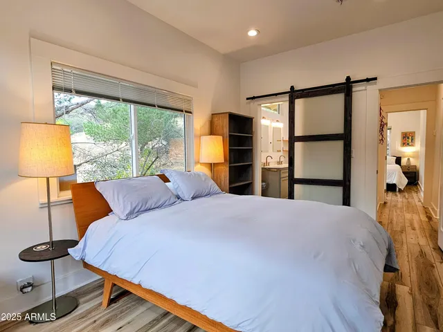 a bedroom with a bed and a large window