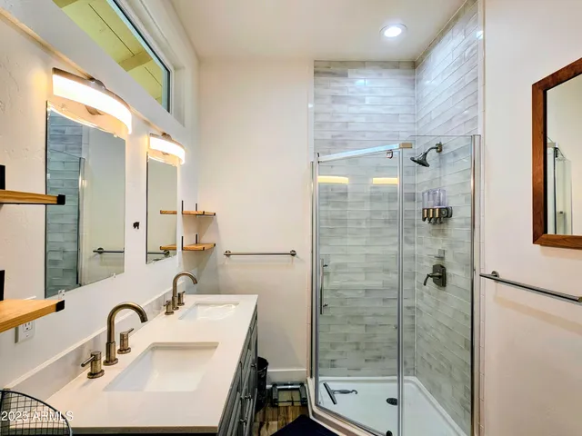 a bathroom with a sink shower and a mirror