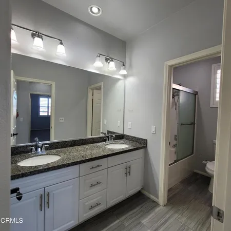 a spacious bathroom with a granite countertop sink mirror and toilet