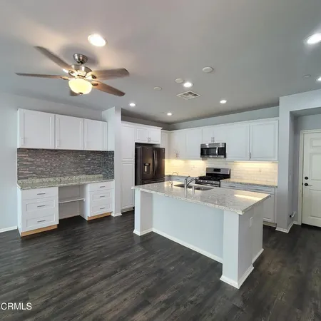 a kitchen with stainless steel appliances a stove top oven a sink dishwasher and a refrigerator
