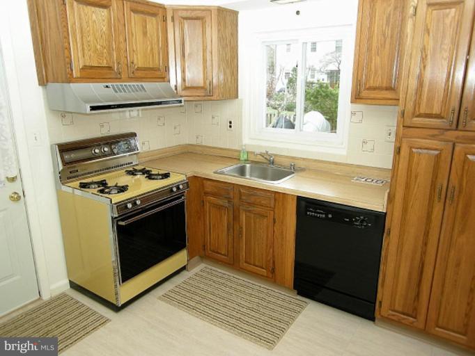 708 Stirling Road Silver Spring, MD 20901 - Photo 3 of 19 a kitchen with stainless steel appliances granite countertop a stove a sink and a microwave