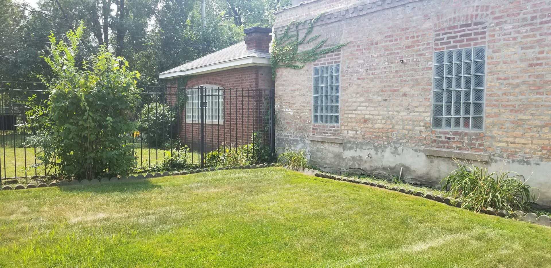 7418 South Rhodes Avenue Chicago, IL 60619 - Photo 36 of 41 a view of a house with a yard and plants