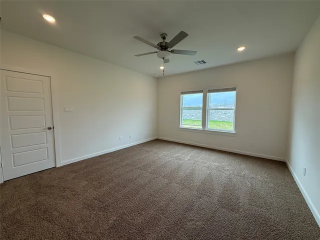 an empty room with a ceiling fan and window