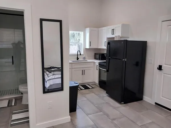 a kitchen with a refrigerator and a stove top open