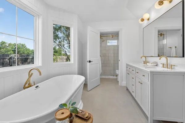 a bathroom with a sink a bathtub and a window