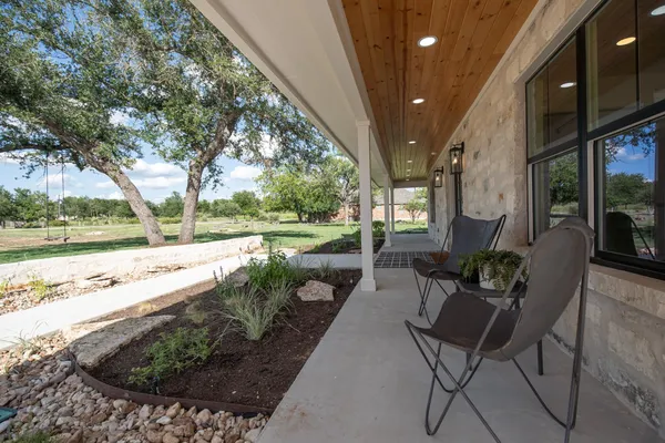 a view of a porch with furniture and garden