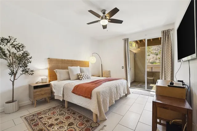 a bedroom with a bed a couch and a flat screen tv