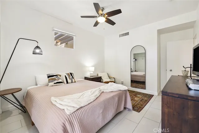 a bedroom with a bed and a dresser with the potted plant