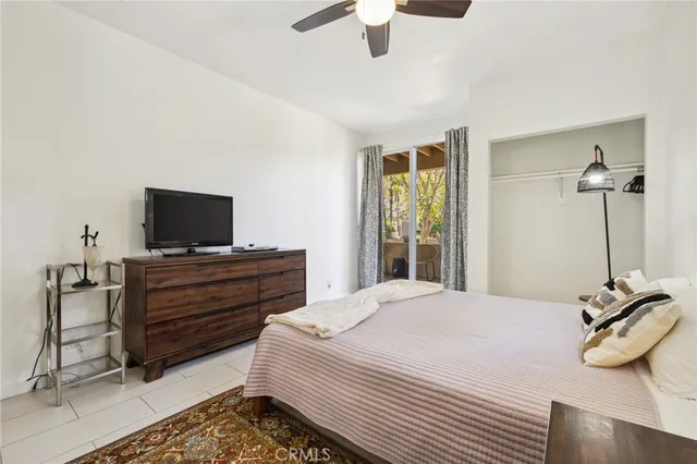 a bedroom with a bed and a flat tv screen on a dresser