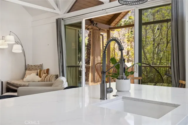a living room with large glass windows and a chandelier