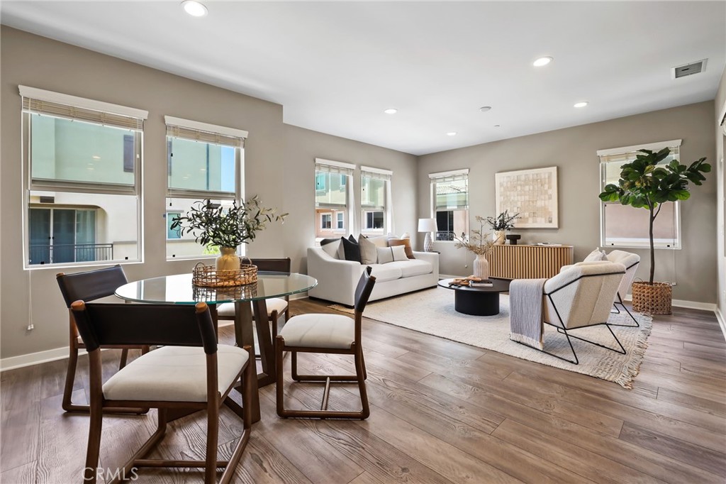a living room with furniture a potted plant and a large window